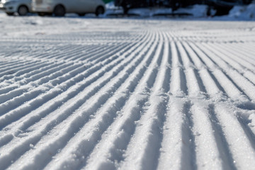 Texture of fresh stripped snowcat traces on snow