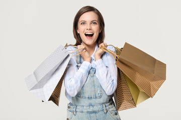 Excited girl holding paper bags enjoy sale isolated on background