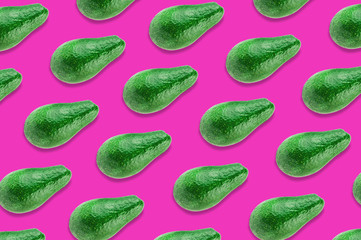 Diagonal rows of green whole fresh raw avocados on pink background