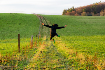 junge Frau springt freudig in die Luft