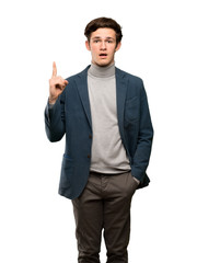 Teenager man with turtleneck thinking an idea pointing the finger up over isolated white background