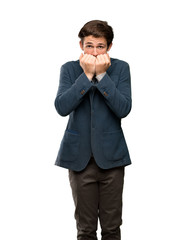 Teenager man with turtleneck nervous and scared putting hands to mouth over isolated white background