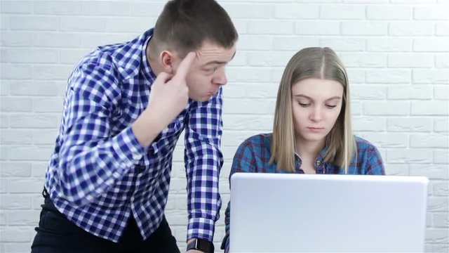 Angry boss yelling at his young employee, she is stressed and feeling frustrated: bullying boss and mobbing concept