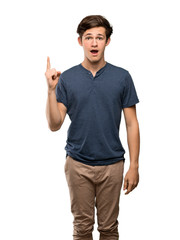 Teenager man thinking an idea pointing the finger up over isolated white background