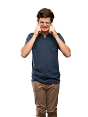 Fototapeta premium Teenager man frustrated and covering ears with hands over isolated white background