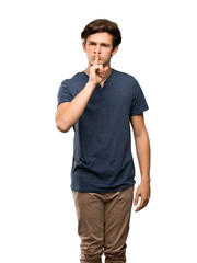 Teenager man showing a sign of silence gesture putting finger in mouth over isolated white background