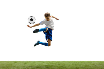 Naklejka premium Young boy with soccer ball running and jumping isolated on white studio background. Junior football soccer player in motion