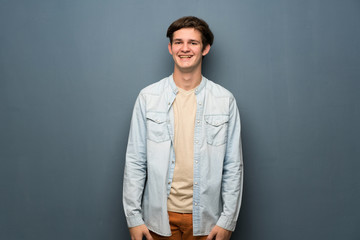 Obraz premium Teenager man with jean jacket over grey wall smiling
