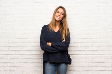 Blonde woman over brick wall Happy and smiling