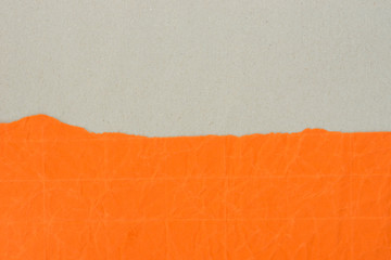 piece of creased orange paper on gray background texture