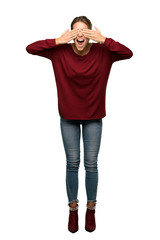 Fototapeta premium A full-length shot of a Blonde woman covering eyes by hands. Surprised to see what is ahead over isolated white background