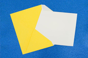 Blank yellow envelope with blank white note on blue