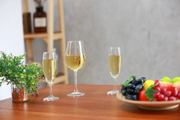 Yellow Wine glasses on wooden table with fruit