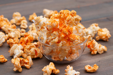 Popcorn in a bowl on wooden background.