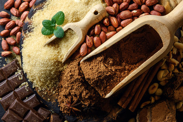 Cocoa powder, chocolate, nuts and spices on a wooden table. Food photography