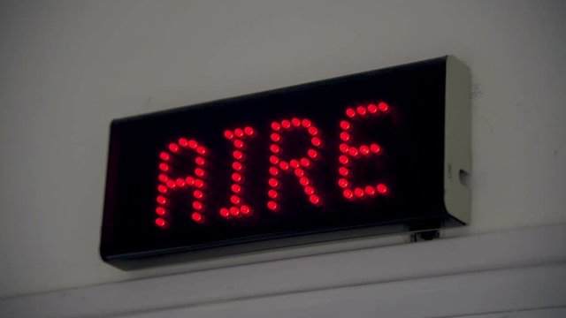 Luminous poster of "air" (aire) in a radio written in Spanish blinking on and off repetitively