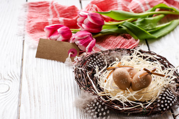 Easter eggs in a nest on a wooden background. - Image