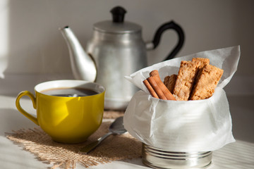 Cookies with cinnamon. Yellow cup with hot tea or coffee. Breakfast, tasty snack.