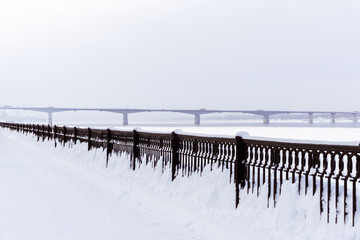 frozen river, quay fence and road bridge away