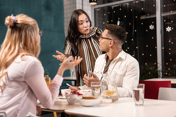 Young woman offended by her boyfriend because he having dinner with her friend.