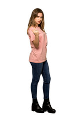 A full-length shot of a Teenager girl with pink sweater making horn gesture on isolated white background