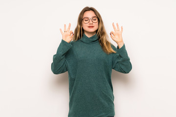 Teenager girl over white wall in zen pose