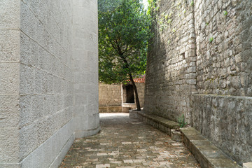 Fototapeta na wymiar Street between two stone walls in an old European city.