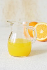A carafe of orange juice for breakfast on a light background. Healthy lifestyle.