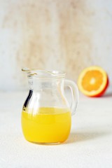 A carafe of orange juice for breakfast on a light background. Healthy lifestyle.