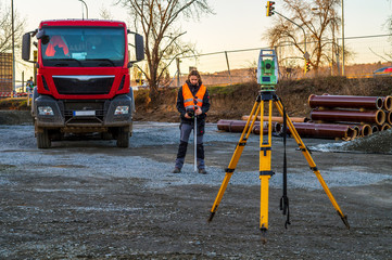 Surveyor engineer with equipment (theodolit or total positioning station) on the construction site...