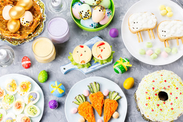Funny colorful Easter food for kids with decorations on table. Easter dinner concept