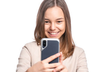 Portrait of beautiful Teen Girl talk to Mobile Phone, isolated on white background. Smiling Child standing and using Cell Phone. Pretty modern Teenager taking Selfie photo on Smartphone.