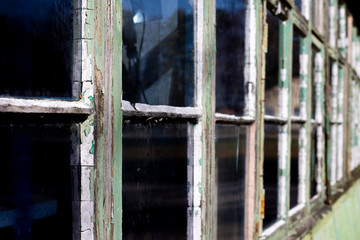 Dilapidated rotten windows on derelict building awaiting demolition with shallow depth of field