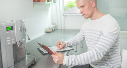 Man working in the kitchen using tablet