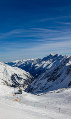 Fototapeta na wymiar Freshly groomed slope descending in to the ravine in the Kingdom of snow Stubaier Gletscher ski resort in the Stubai valley, Tirol, Austria