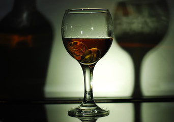 brandy in a glass on a black glass with reflection