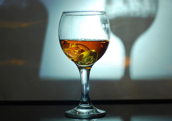 brandy in a glass on a black glass with reflection