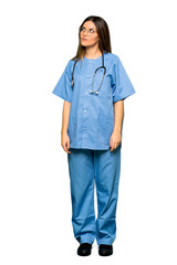 Full body of Young nurse looking up with serious face