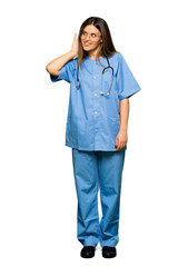 Full body of Young nurse listening to something by putting hand on the ear