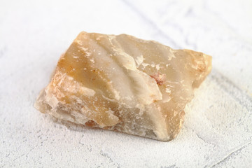 Agate-perelift from Shaytanka deposit, Middle Urals, Russia on white cement background. Perelift is a local name for agate-like banded massive rock.