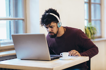 Man in front of laptop computer with headset