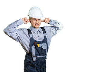 A young construction engineer covers his ears with his hands. He is not happy with the noise level at the construction site. isolated