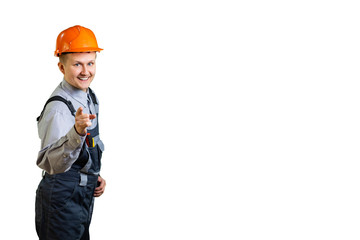 a young construction engineer happily pointing at you. For you the most favorable conditions for high-quality repair or construction of buildings. isolated