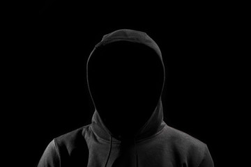 faceless man in hoodie standing isolated on black