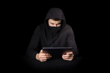 Hacker with tablet PC initiating cyber attack, isolated on black