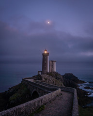 Isolated lighthouse path and moon over Petit Minou tower in France