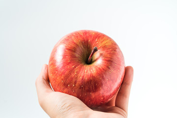 Holding an apple in the hand from below isolated on white background