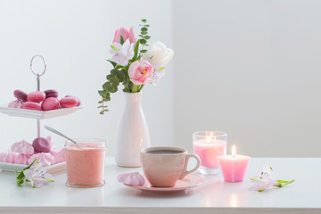 Tulips in vase and cup of coffee with dessert on white background. Concept woman's or mother's day