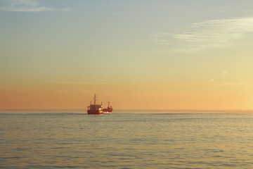 Boat on the ocean with sunset colors