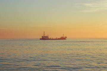 Boat on the ocean with sunset colors